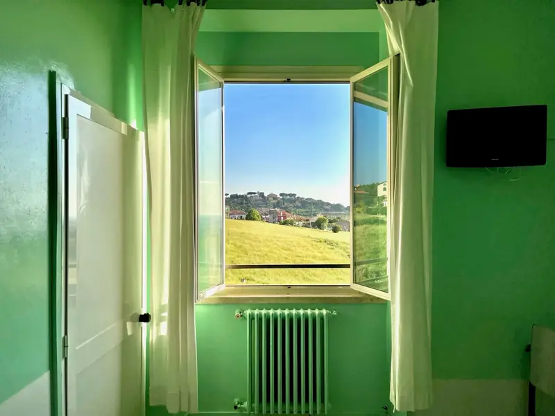 Camera con finestra affacciata sul verde