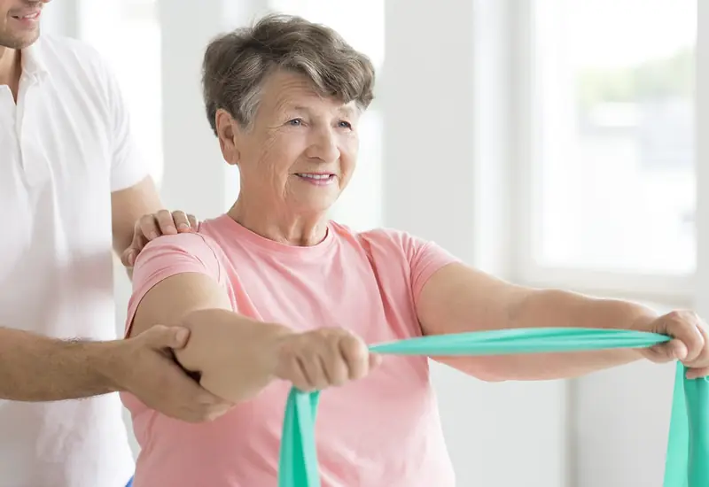 Esercizi di fisioterapia con l’elastico insieme alla fisioterapista